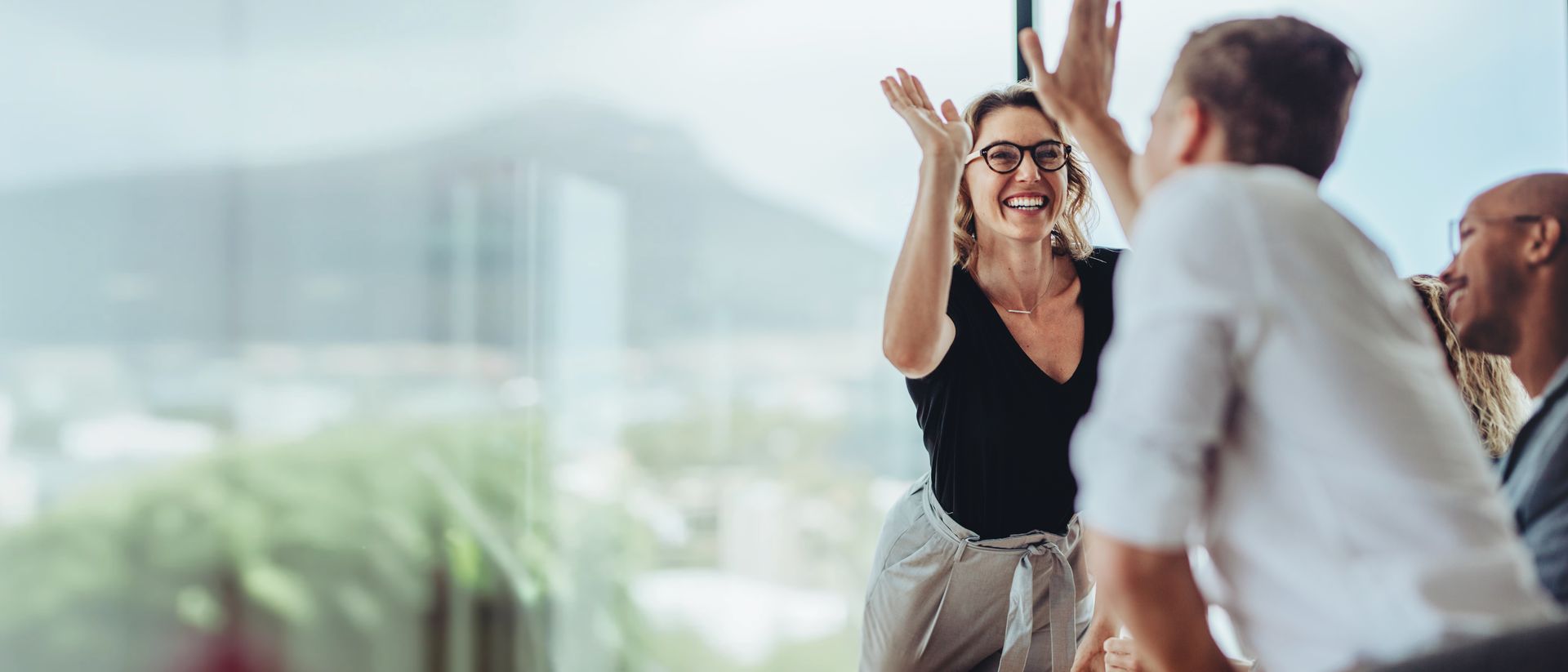 Confident business leader celebrating with her team